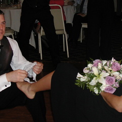 Eric puts the garter on his date's leg.